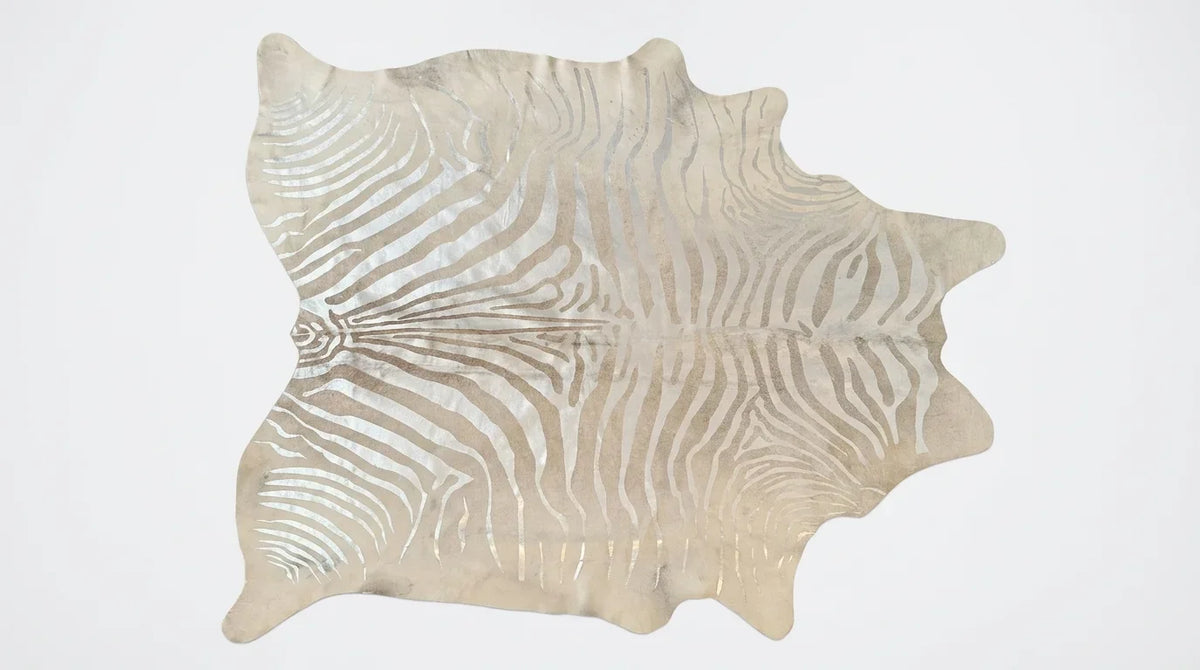 Beige and White cowhide rug flat lay on white background showing full hide shape