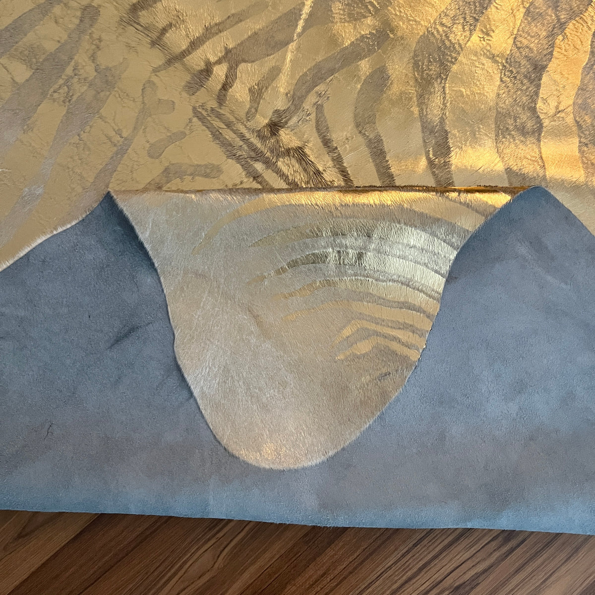 Close-up texture of Beige and White zebra print cowhide rug — Bold zebra-stripe radiating pattern in grey-brown tones over cr