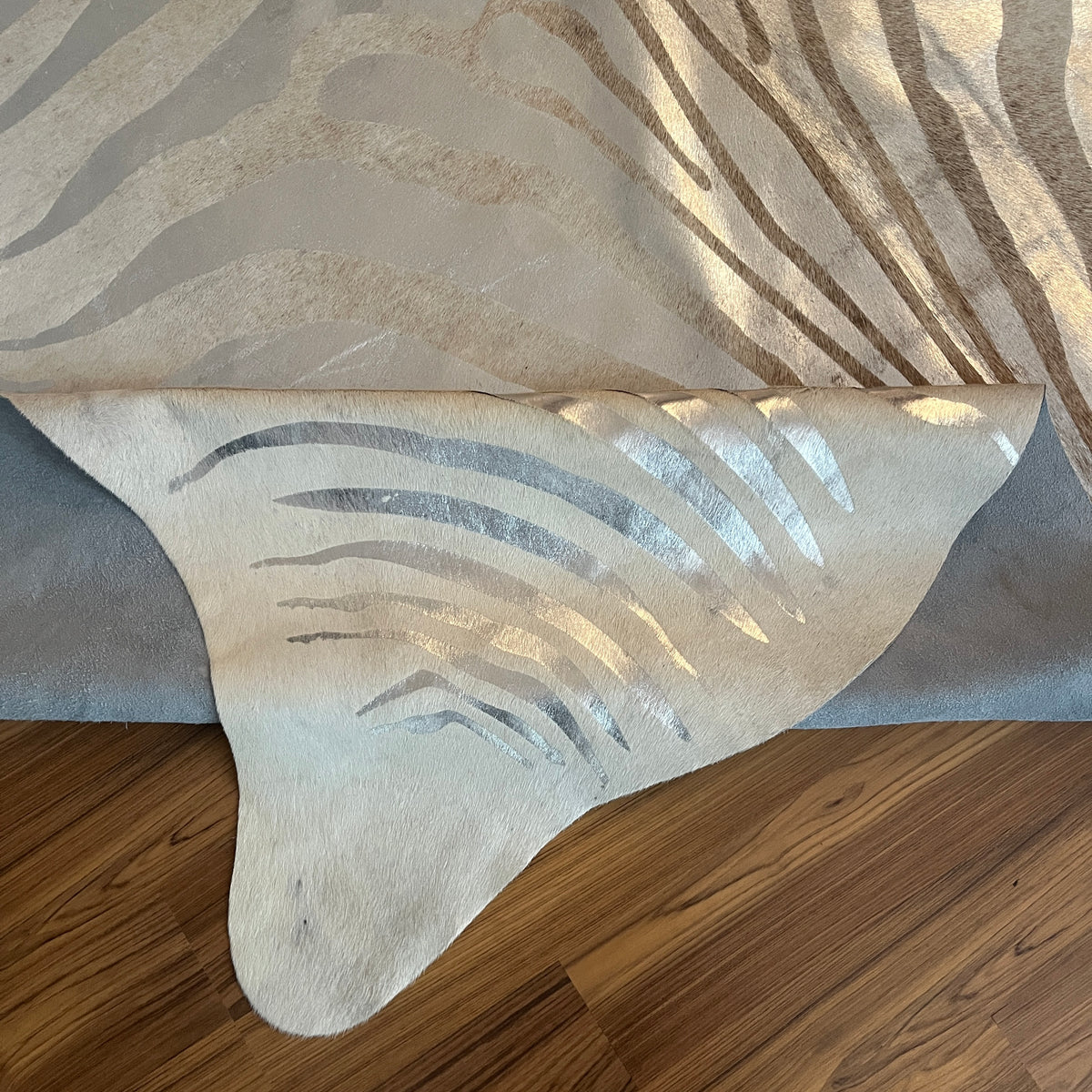 Close-up texture of Beige and White zebra print cowhide rug — Bold zebra stripes radiating from center in cream and taupe ton