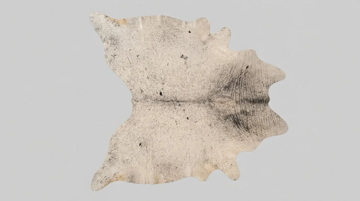 Beige cowhide rug flat lay on white background showing full hide shape