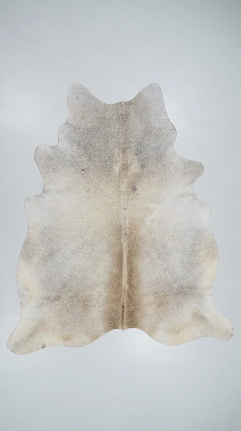 Beige cowhide rug flat lay on white background showing full hide shape