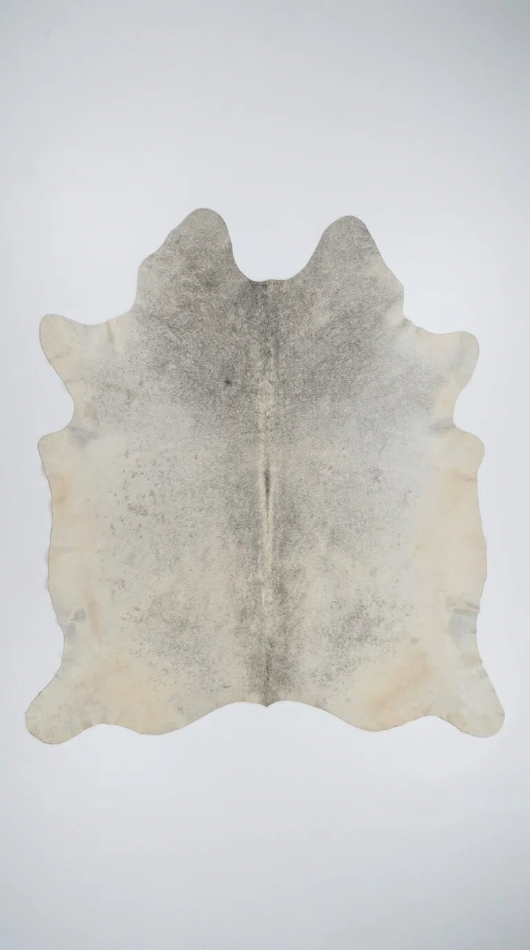 Beige cowhide rug flat lay on white background showing full hide shape