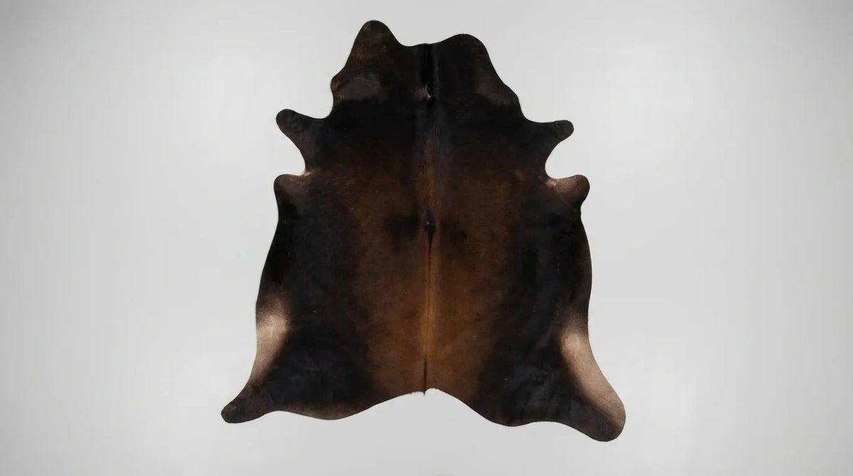 Black and White cowhide rug flat lay on white background showing full hide shape