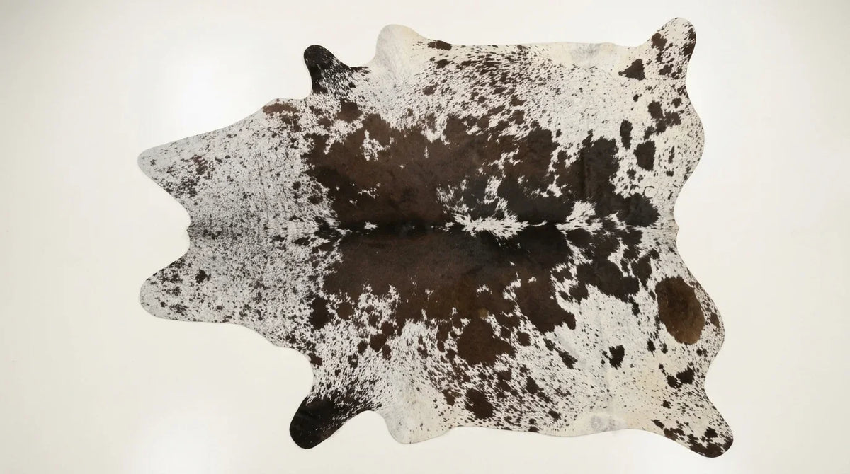 Black and White cowhide rug flat lay on white background showing full hide shape