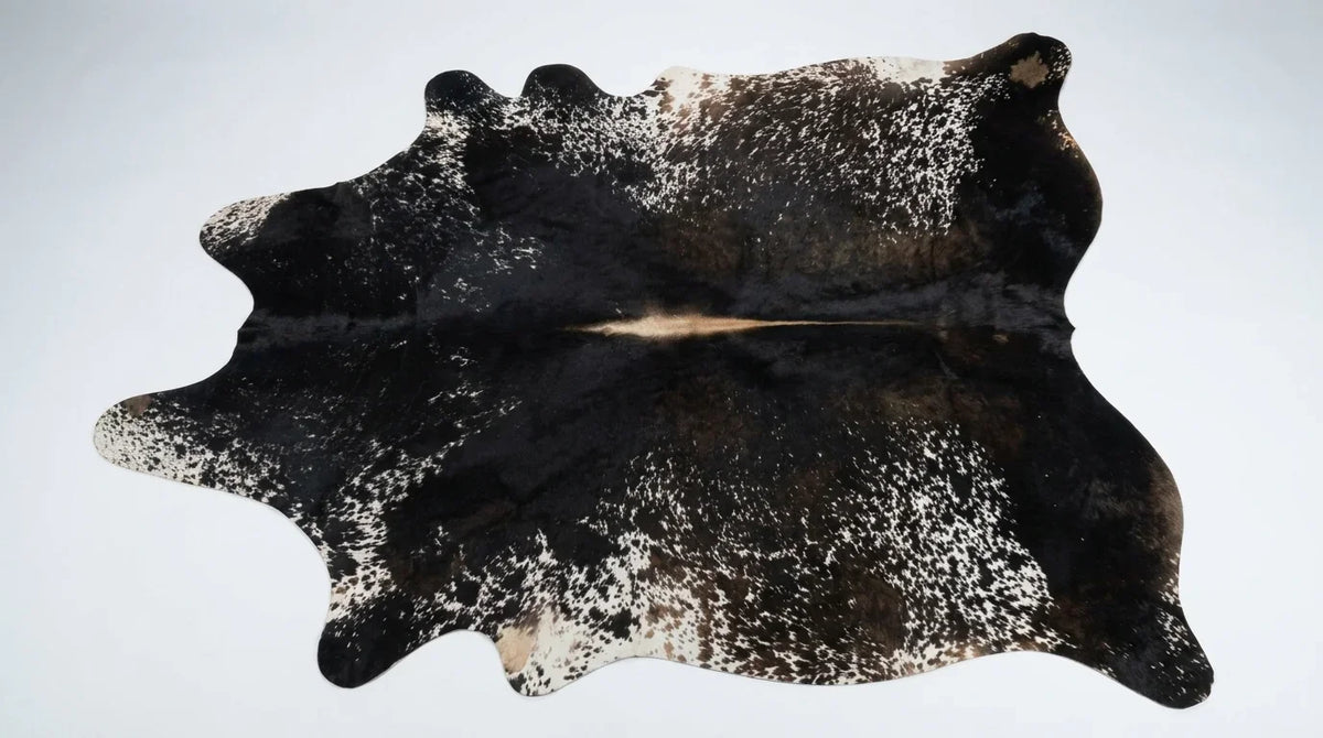 Black and White cowhide rug flat lay on white background showing full hide shape