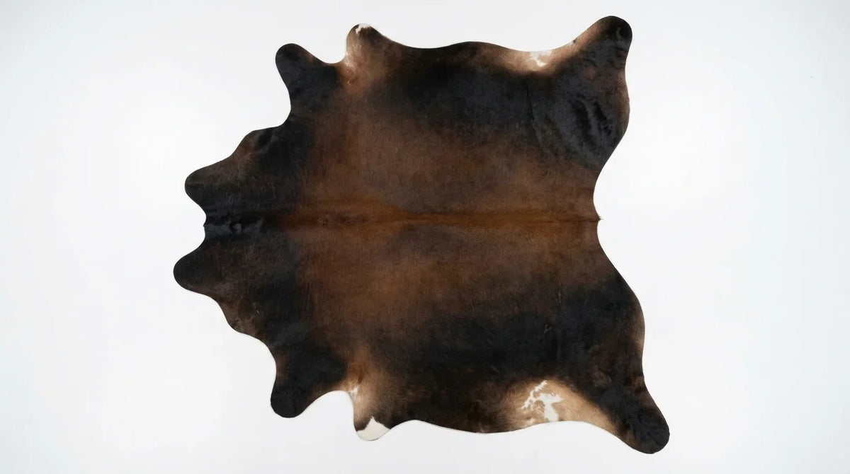 Black and White cowhide rug flat lay on white background showing full hide shape