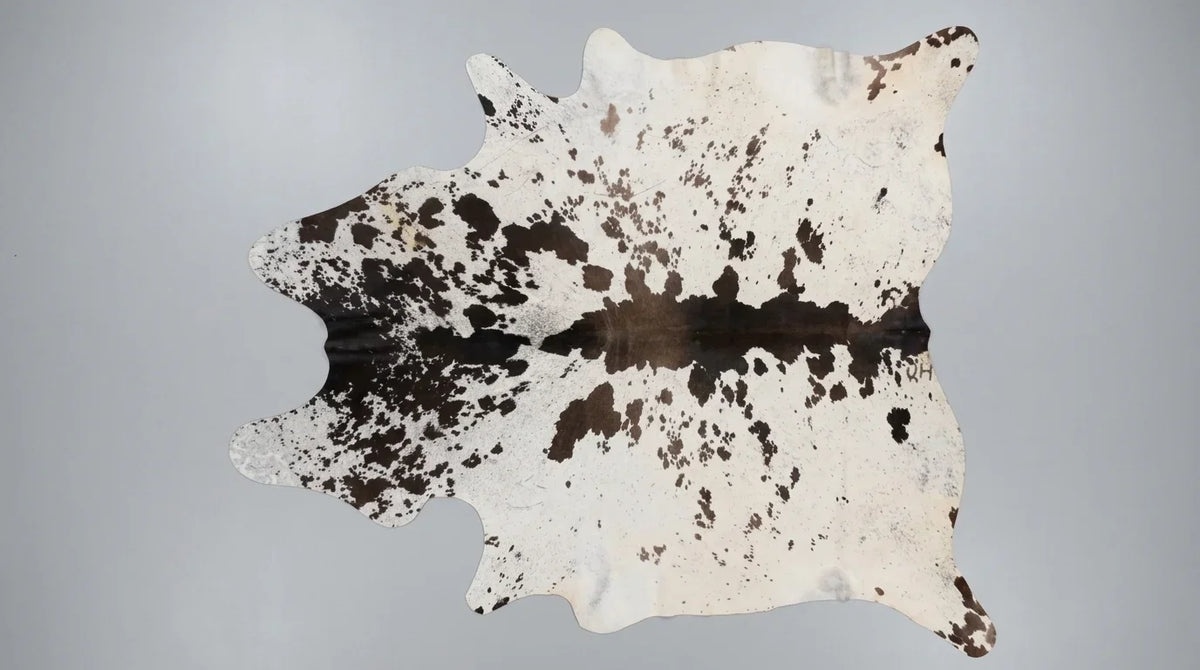 Black and White cowhide rug flat lay on white background showing full hide shape