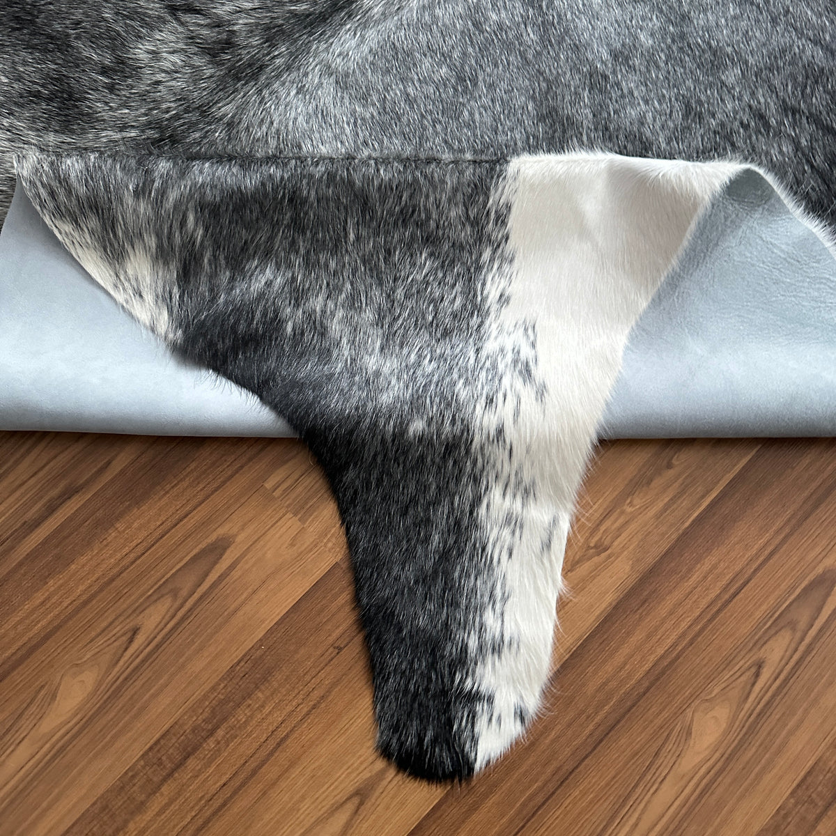 Close-up texture of Black and White cowhide rug — Large irregular dark patches over cream and white base with natural hide co