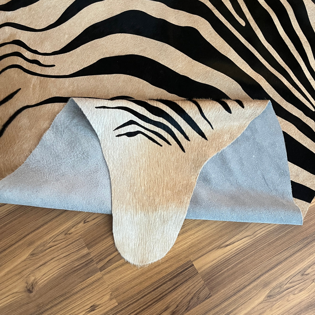 Close-up texture of Black and White zebra print cowhide rug — Bold black stripes radiating from center over cream-white base