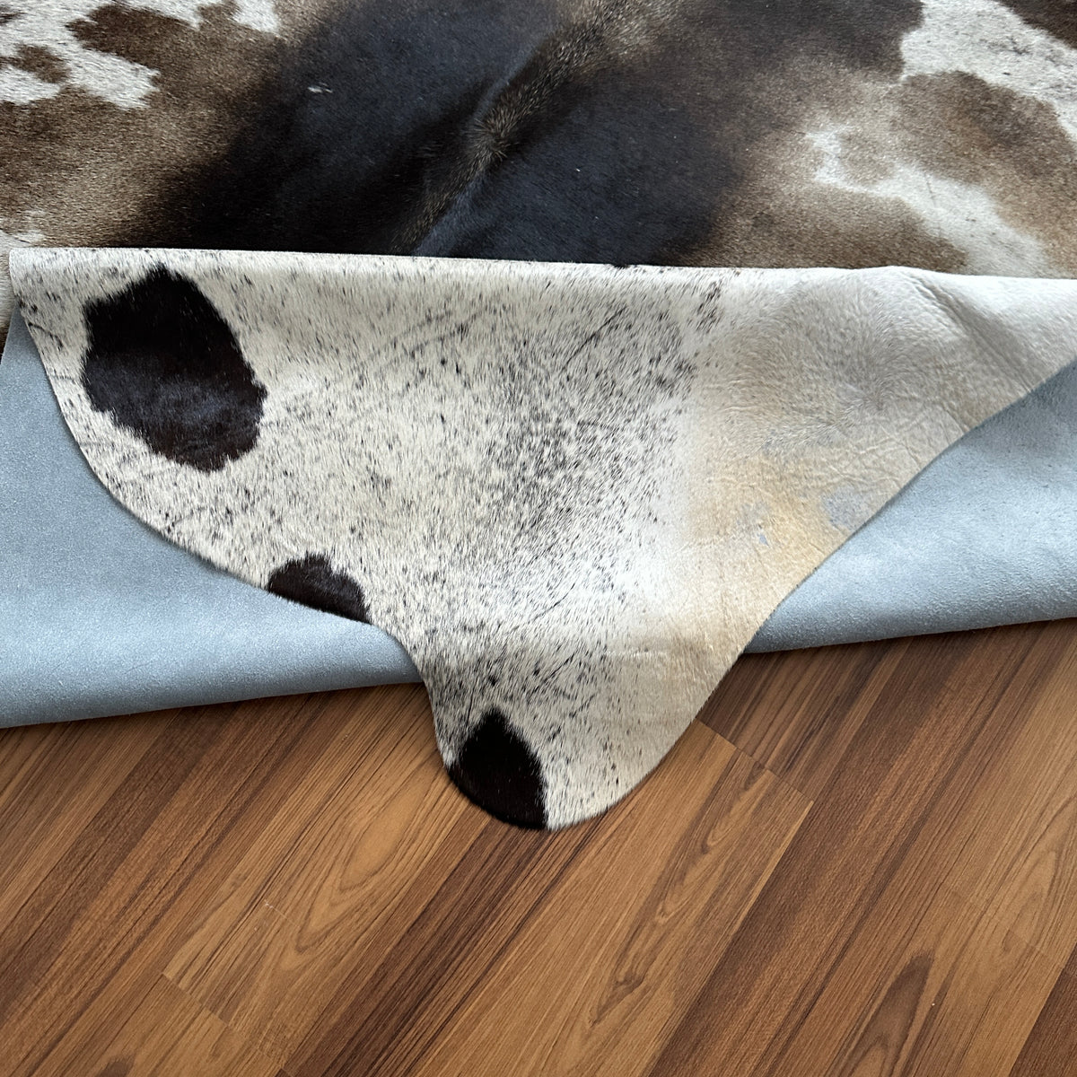 Close-up texture of Black and White cowhide rug — Large irregular dark brown patches with white and cream base, natural organ