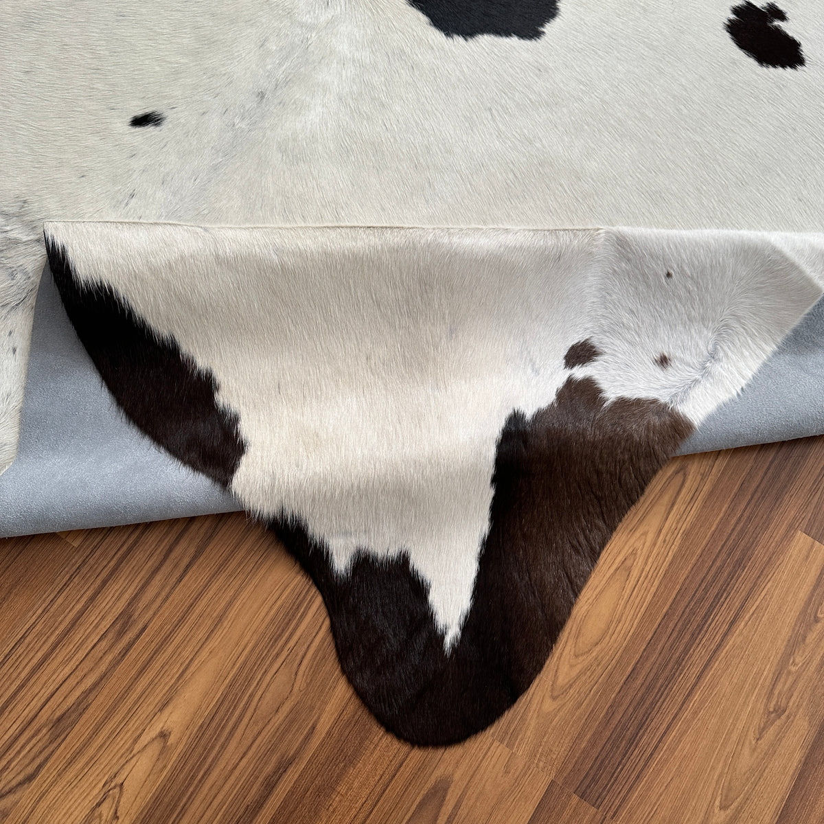 Close-up texture of Black and White cowhide rug — Large irregular black patches scattered across white base with organic dist