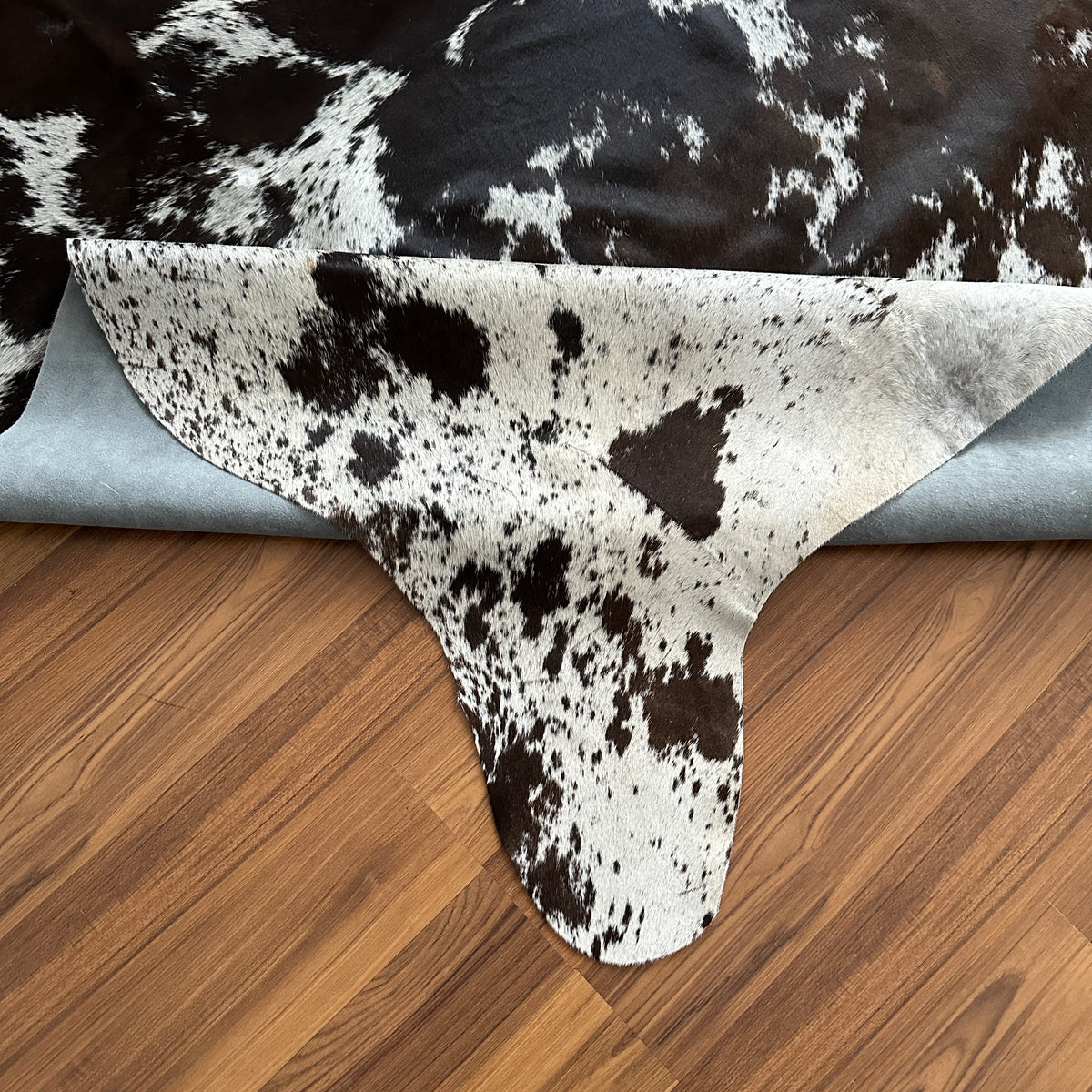 Close-up texture of Black and White cowhide rug — Large irregular dark brown patches with fine speckled undertones over cream