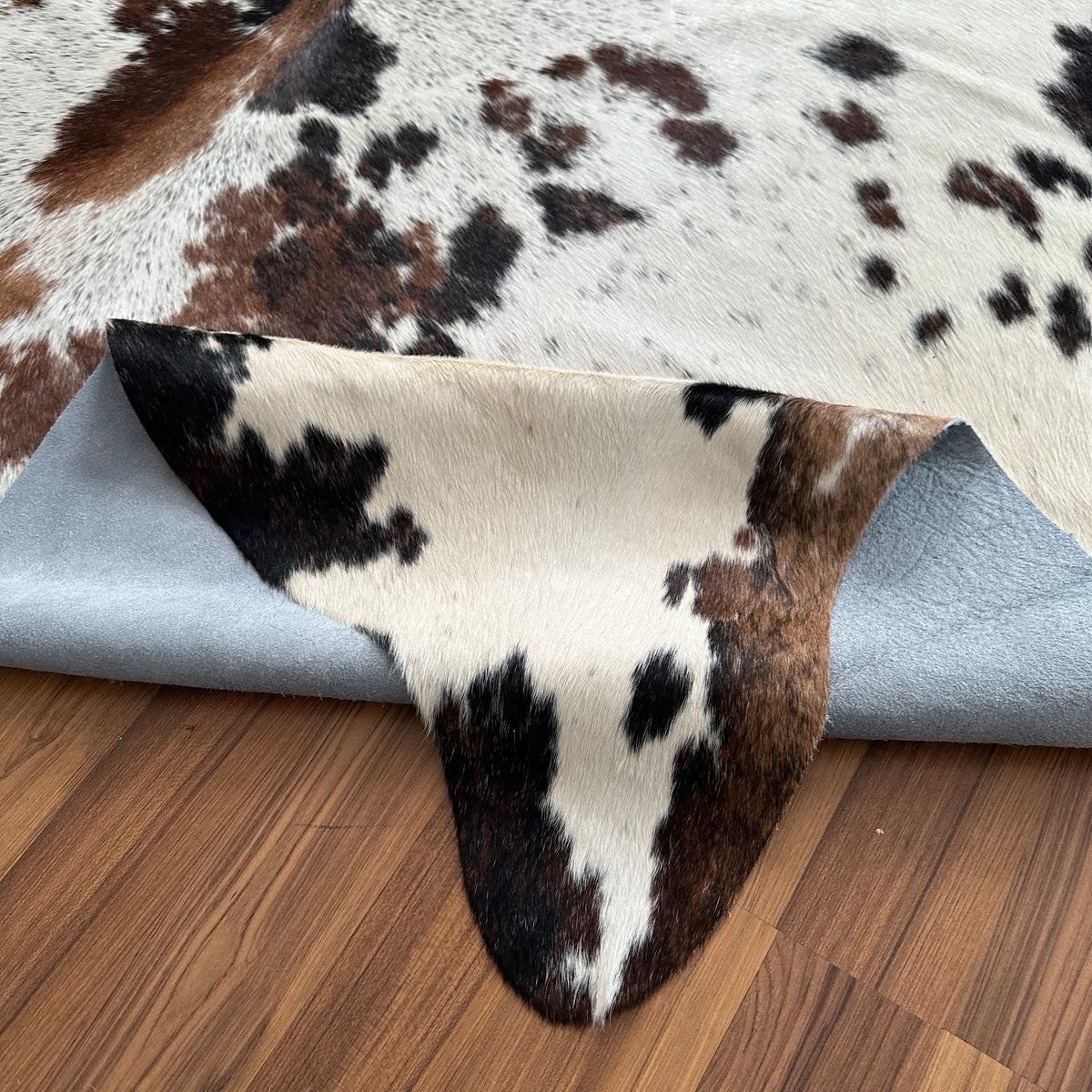 Close-up texture of Black and White cowhide rug — Large irregular black patches with brown undertones over cream-white base