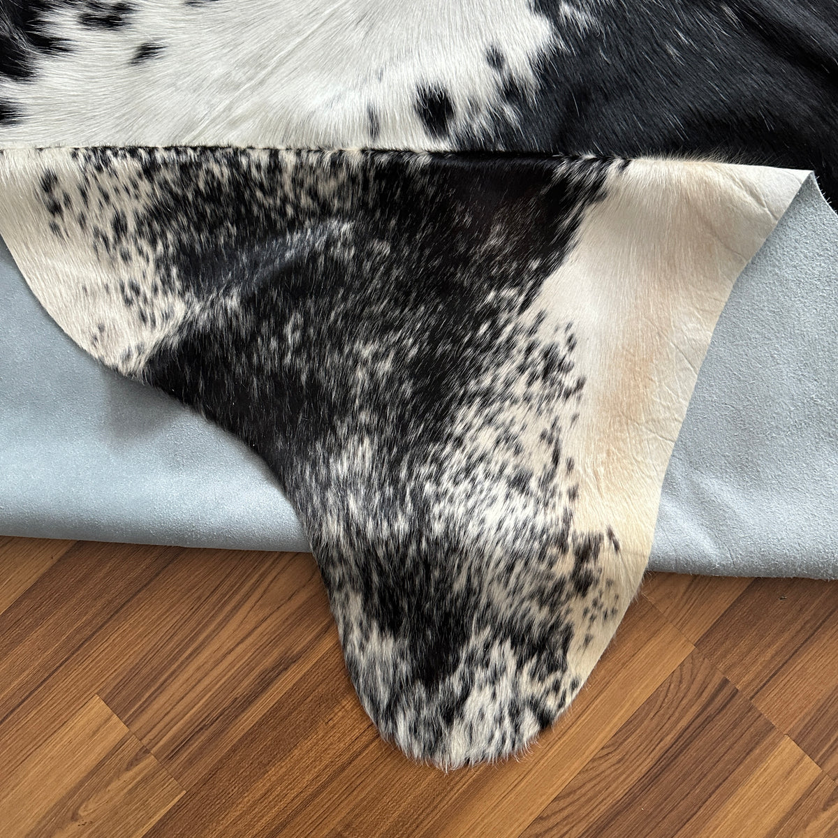 Close-up texture of Black and White cowhide rug — Large irregular black patches with white base and central white stripe