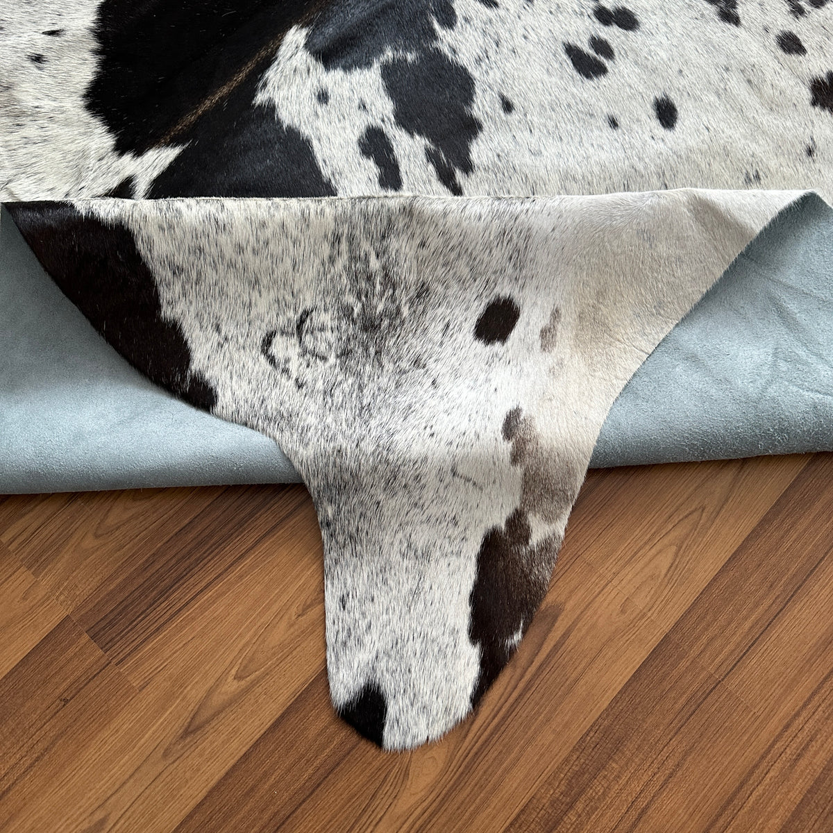 Close-up texture of Black and White cowhide rug — Large irregular black patches and speckles over white cream base