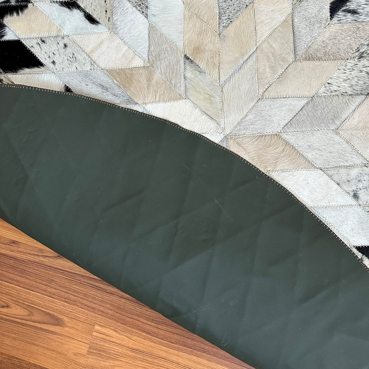 Close-up texture of Black and White round patchwork cowhide rug — Geometric star burst design radiating from center, assemble