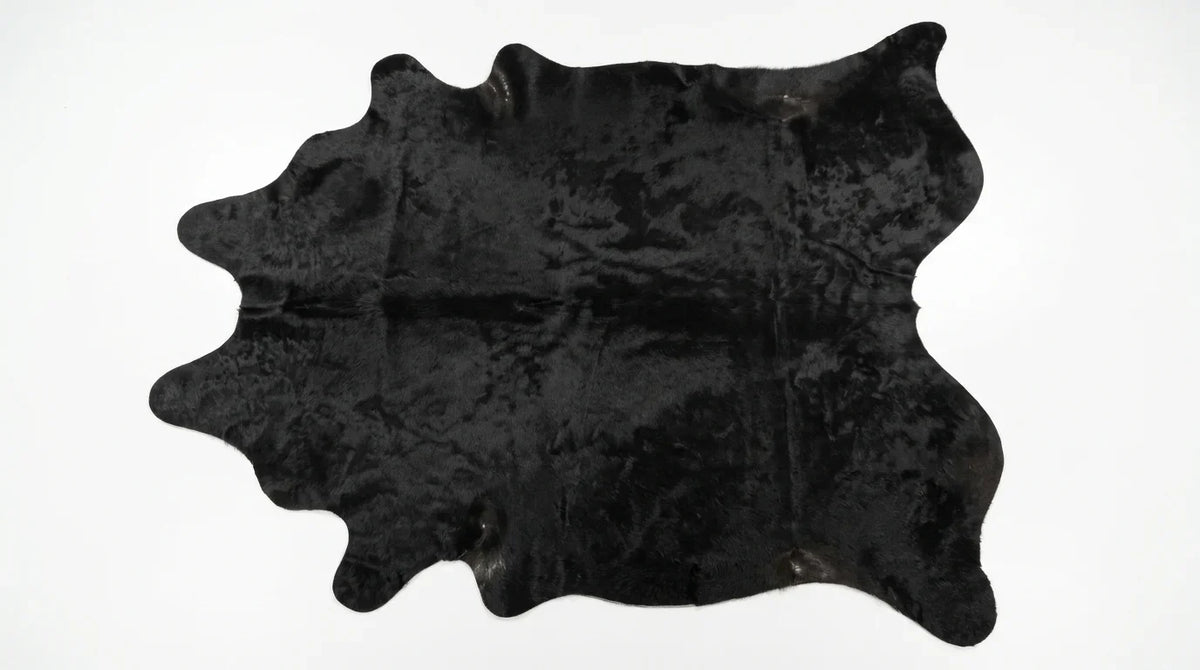 Kuhfell in Schwarz mit Einfarbig Schwarz, auf weißem Hintergrund, Draufsicht, ganze Fellform sichtbar