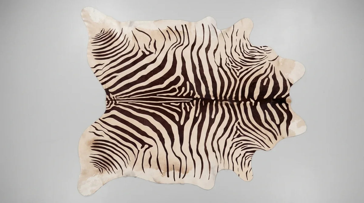 Brown and White cowhide rug flat lay on white background showing full hide shape