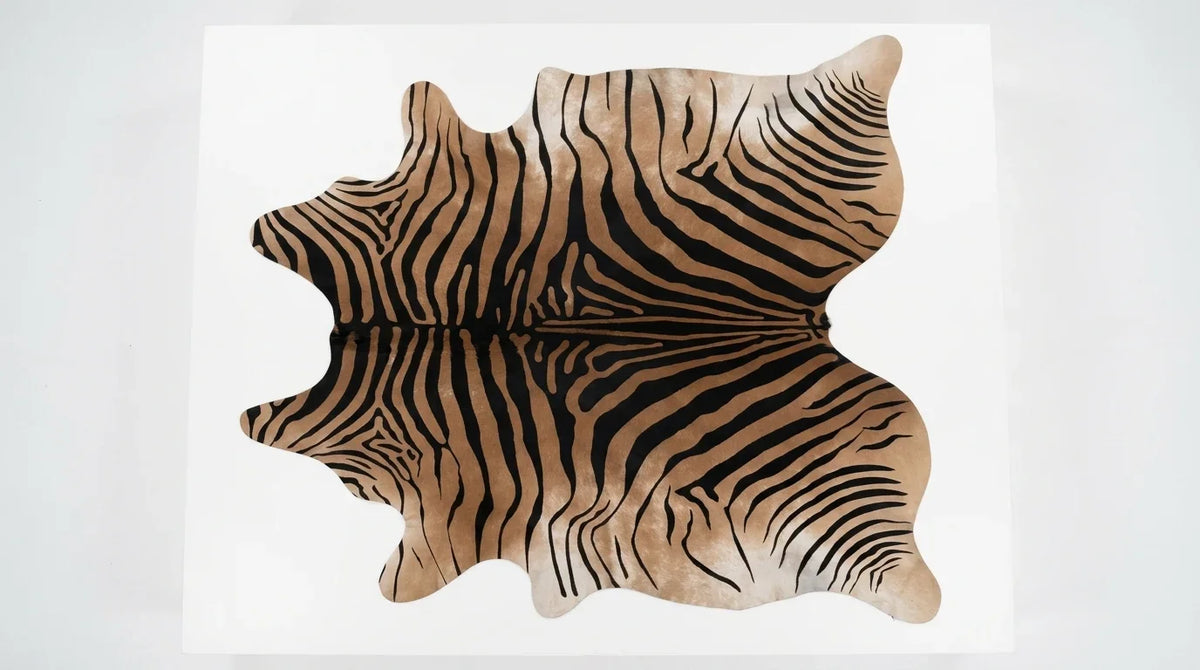 Brown and White cowhide rug flat lay on white background showing full hide shape