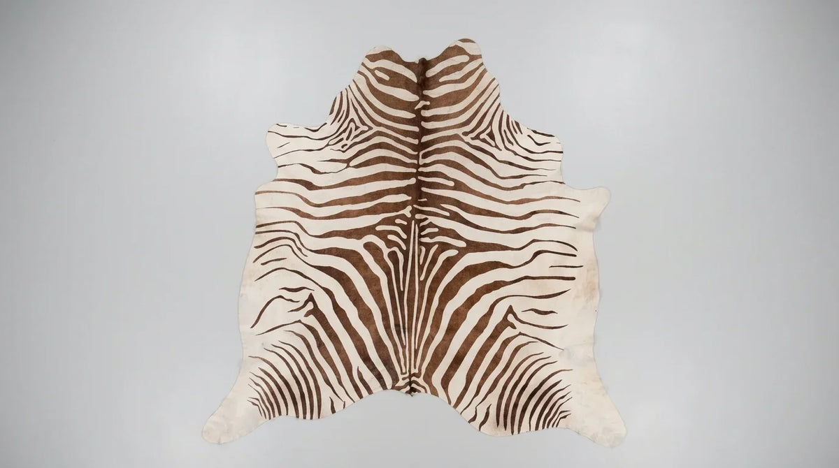 Brown and White cowhide rug flat lay on white background showing full hide shape