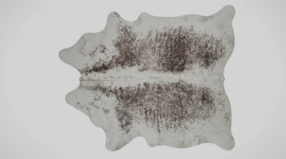 Brown and White cowhide rug flat lay on white background showing full hide shape