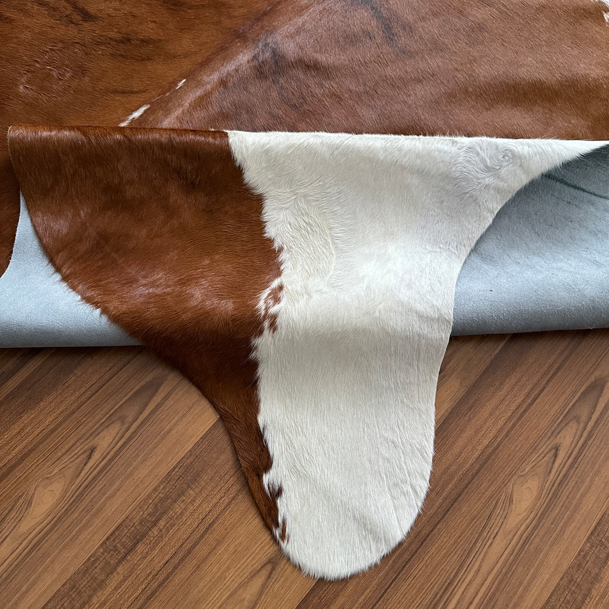 Close-up texture of Brown and White cowhide rug — Large irregular chocolate brown patches over creamy white base with natural