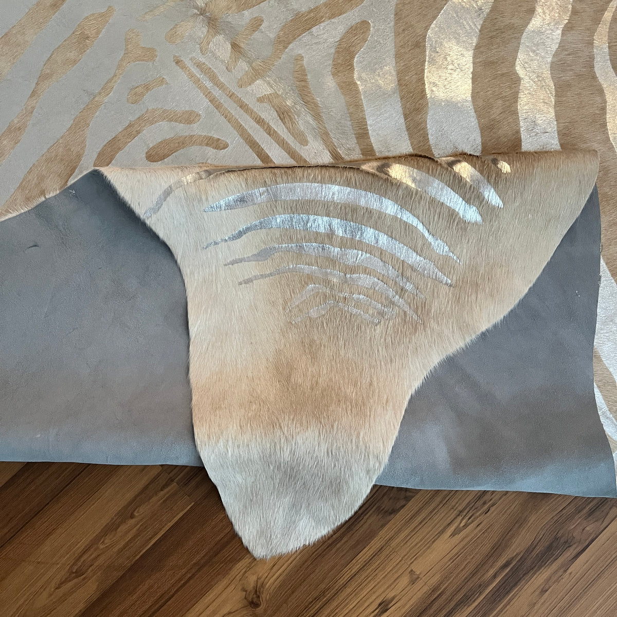 Close-up texture of Brown and White zebra print cowhide rug — Bold zebra-stripe pattern radiating from center in cream and wa