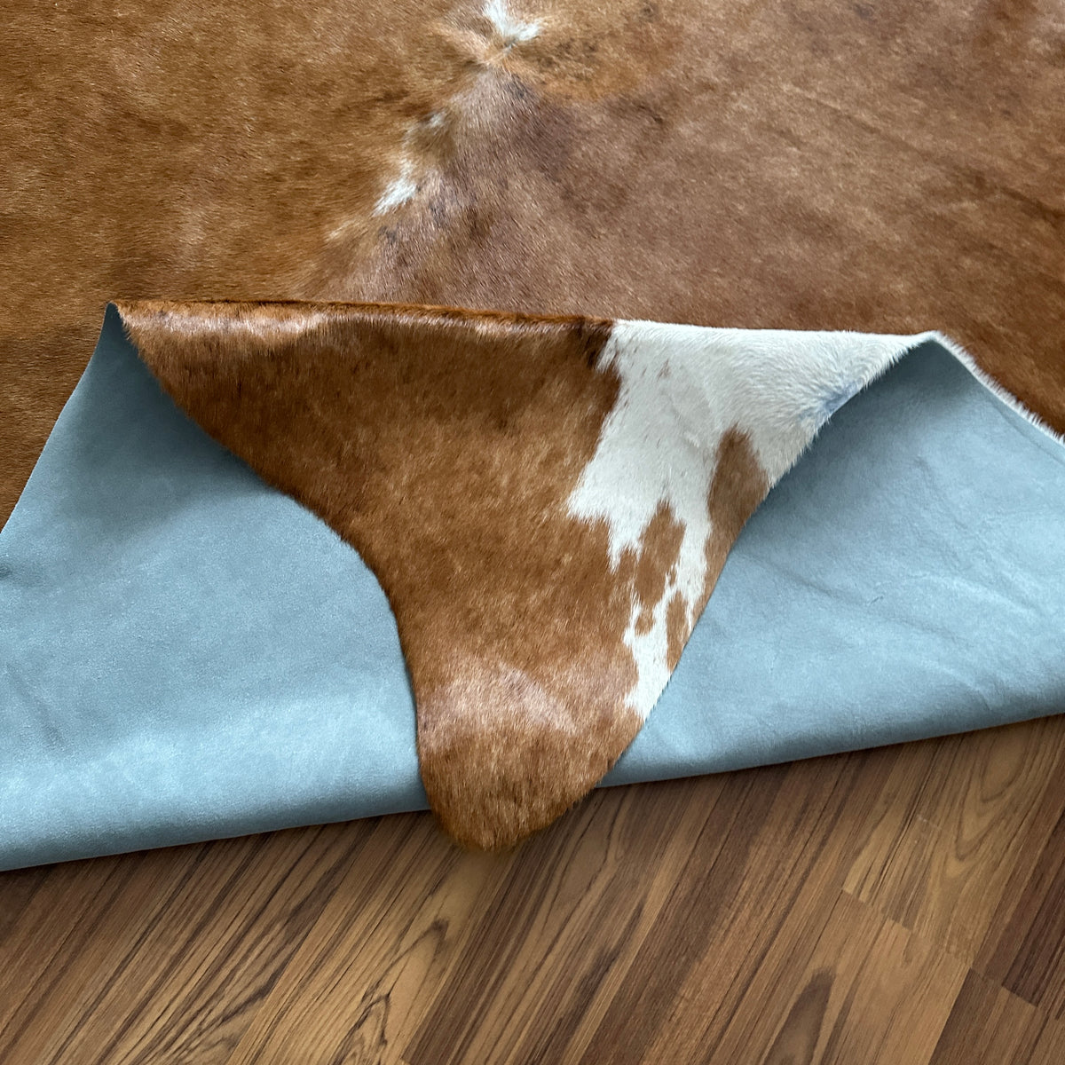 Close-up texture of Brown and White cowhide rug — Large irregular chocolate brown patches over cream and white base