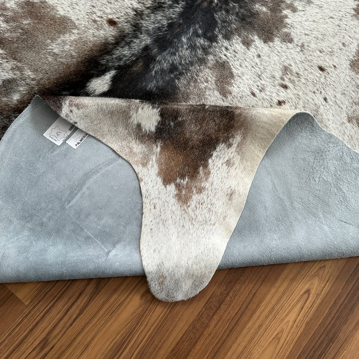Close-up texture of Brown and White cowhide rug — Large irregular chocolate brown patches over cream and white base