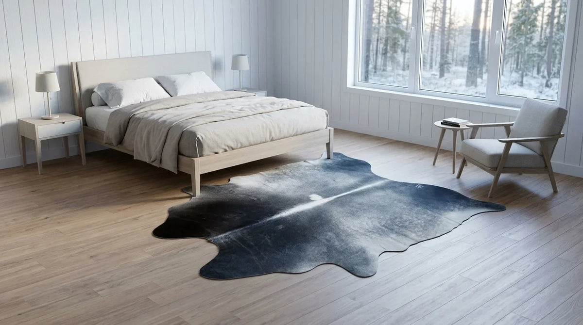 Grey cowhide rug beside bed in scandinavian cabin bedroom