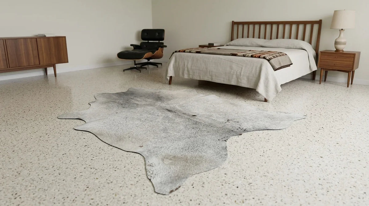 Grey cowhide rug beside bed in midcentury modern bedroom