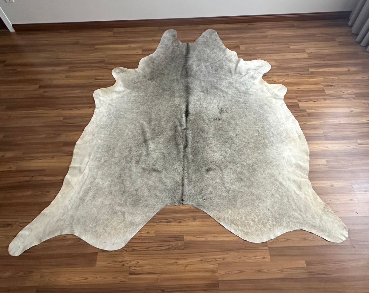 Grey cowhide rug, full overhead view — Light grey base with subtle darker grey patches and natural markings