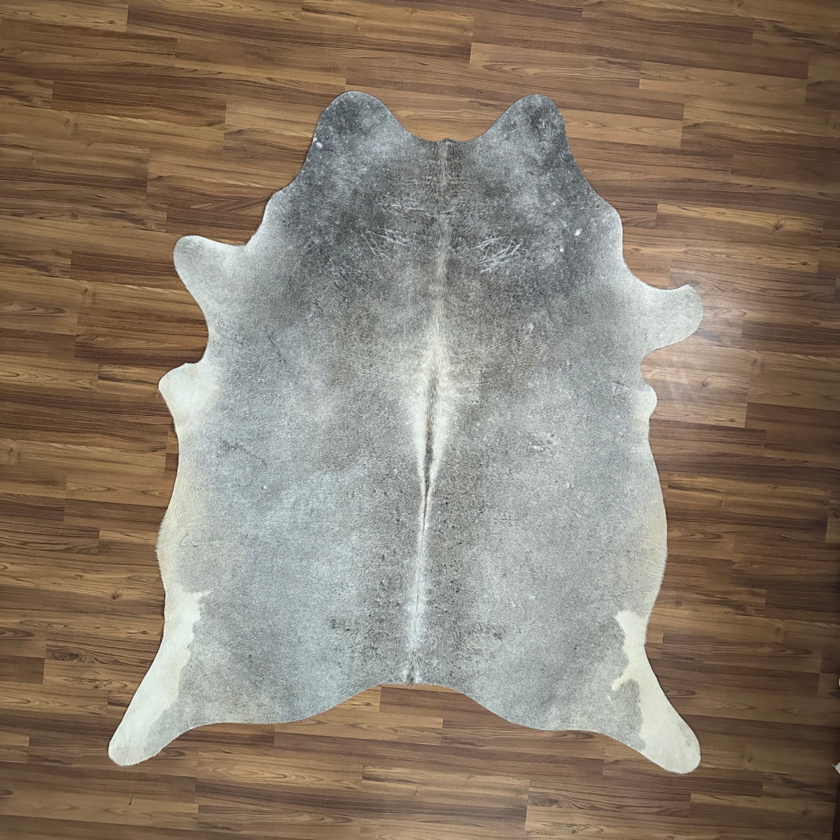 Grey cowhide rug, full overhead view — Fine salt-and-pepper texture with darker grey patches over cream-white base
