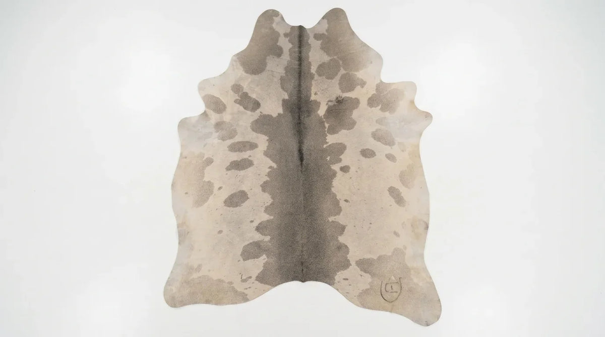 Grey cowhide rug flat lay on white background showing full hide shape