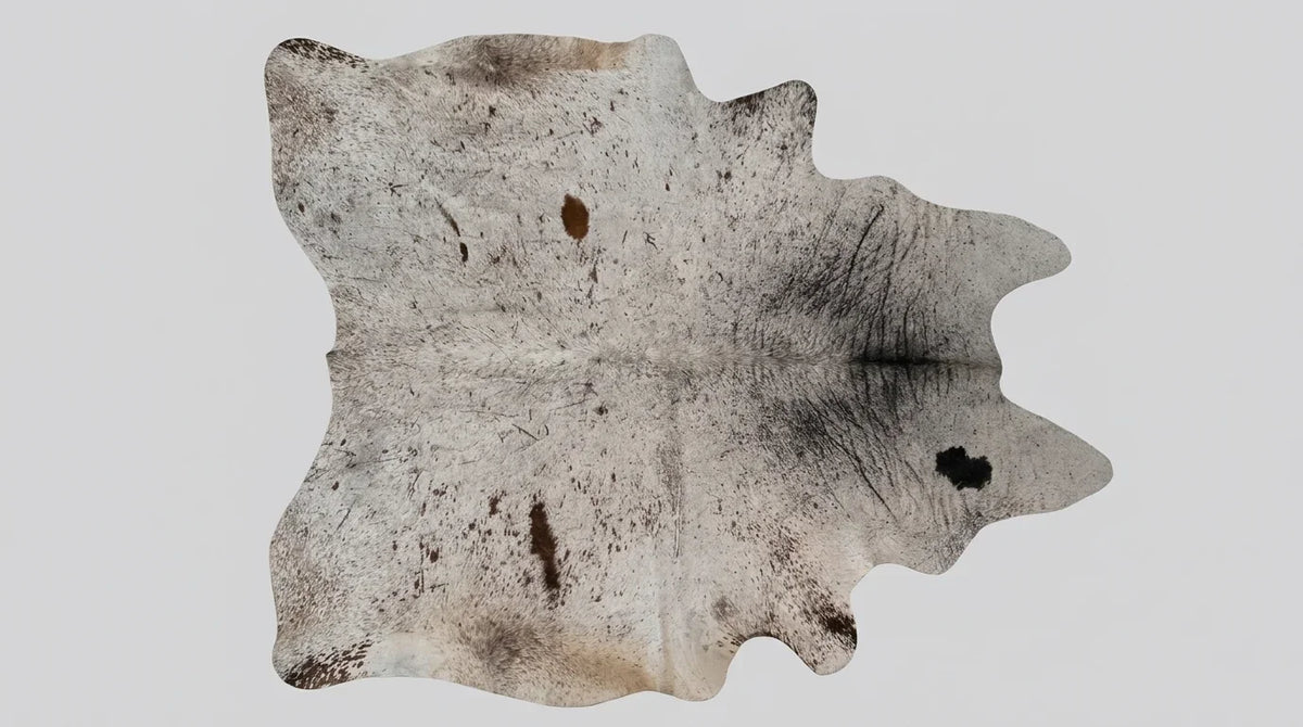 Grey cowhide rug flat lay on white background showing full hide shape