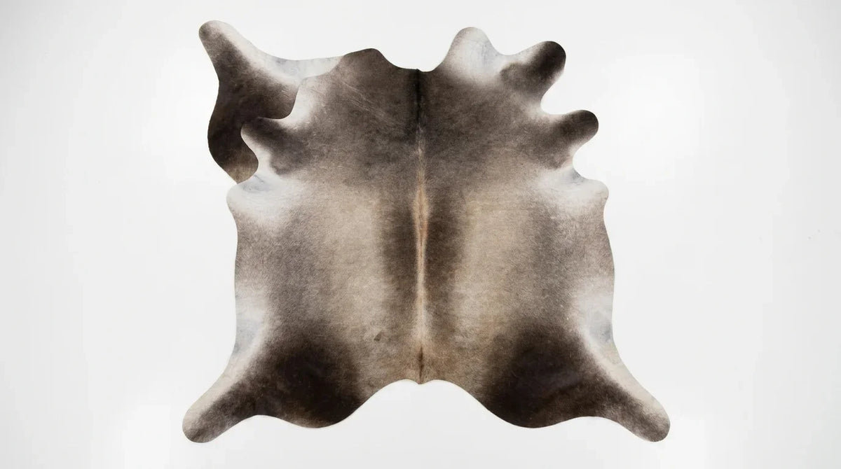Grey cowhide rug flat lay on white background showing full hide shape
