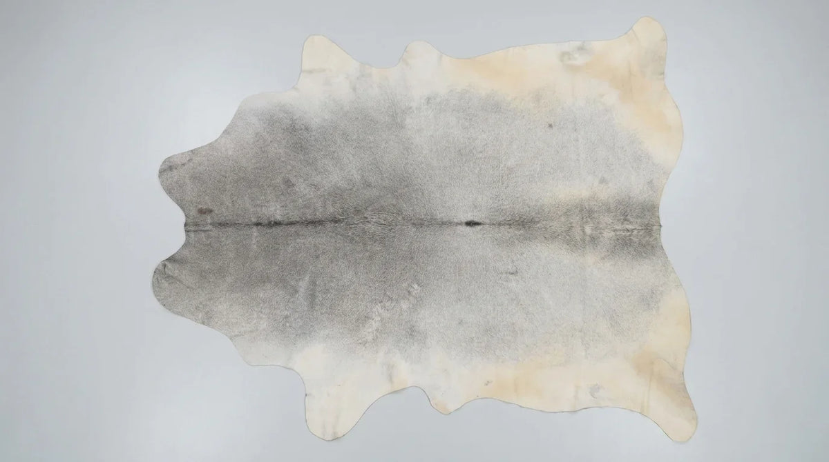 Grey cowhide rug flat lay on white background showing full hide shape
