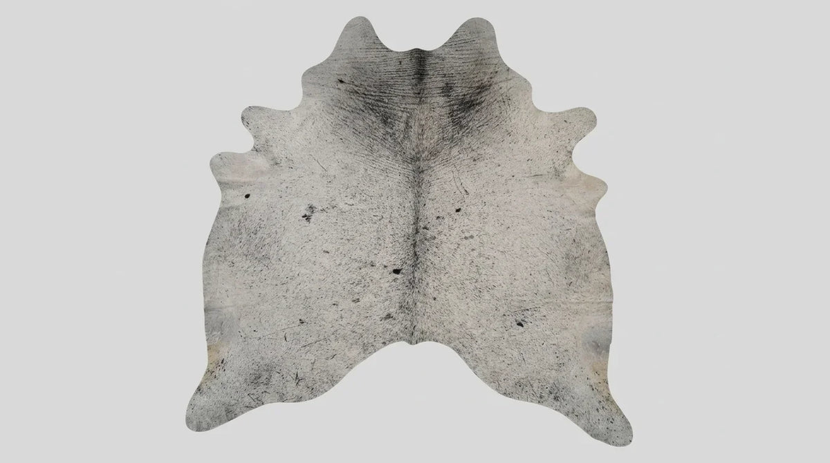 Grey cowhide rug flat lay on white background showing full hide shape