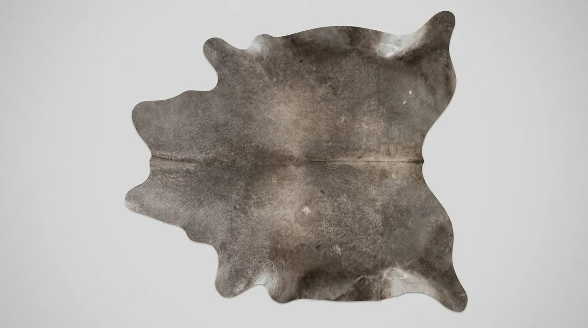Grey cowhide rug flat lay on white background showing full hide shape