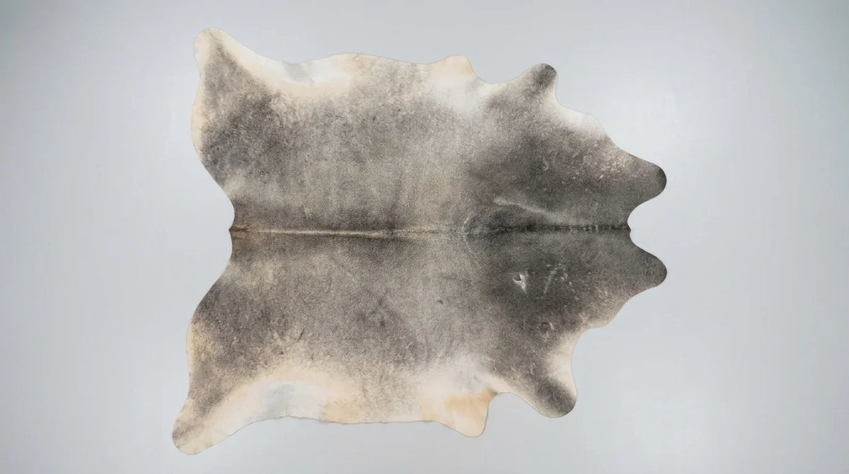 Grey cowhide rug flat lay on white background showing full hide shape