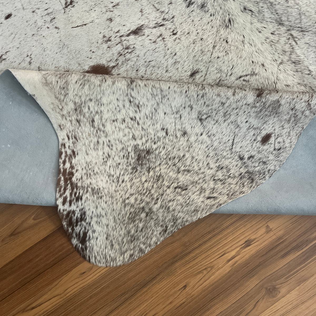 Close-up texture of Grey salt and pepper cowhide rug — Fine even speckle of dark and light hairs throughout, with darker patc