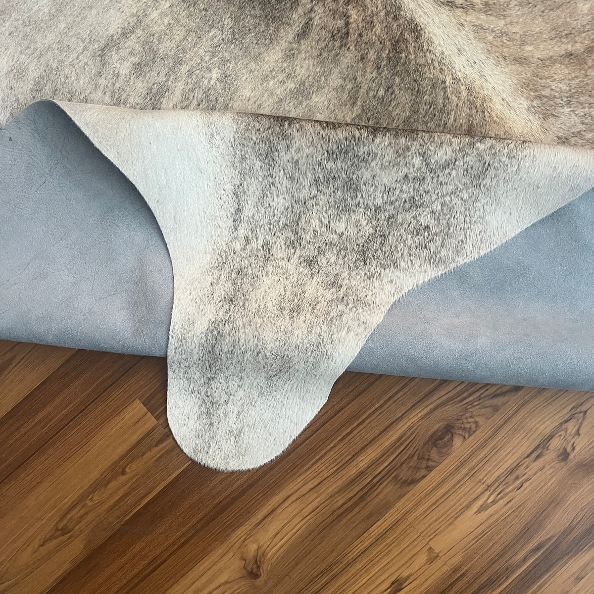 Close-up texture of Grey cowhide rug — Large irregular charcoal and cream patches with natural hide variation