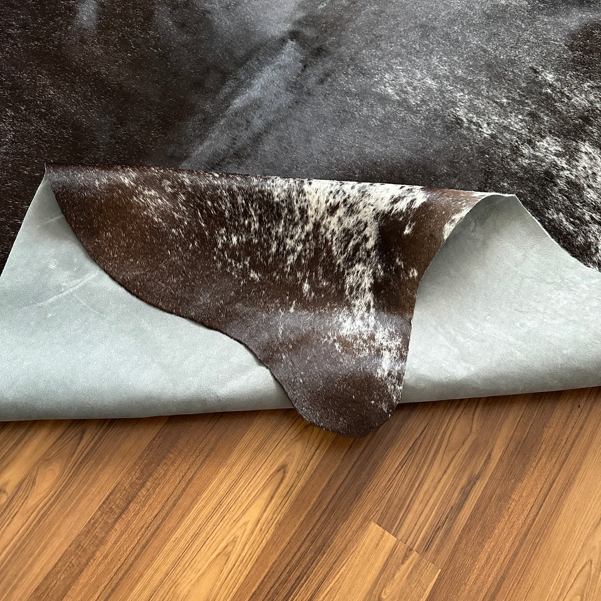 Close-up texture of Grey salt and pepper cowhide rug — Fine even speckle of dark and light hairs throughout, creating a peppe