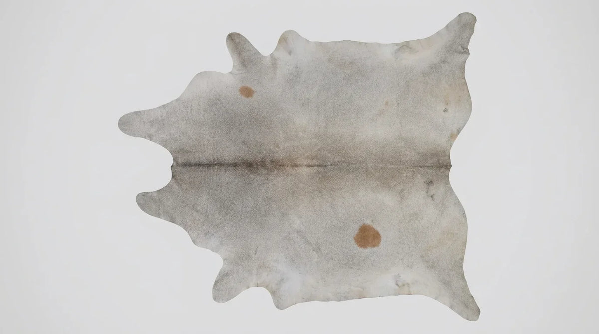 Beige cowhide rug flat lay on white background showing full hide shape