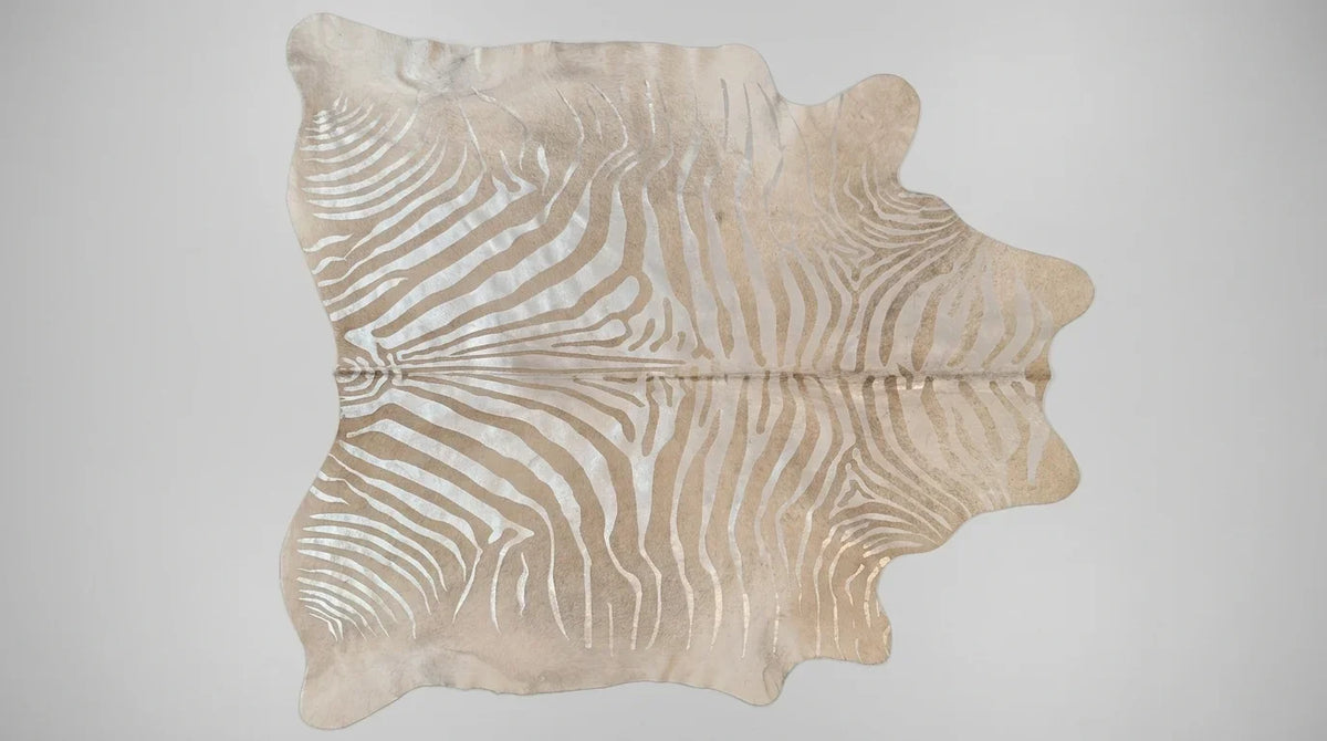 Beige cowhide rug flat lay on white background showing full hide shape