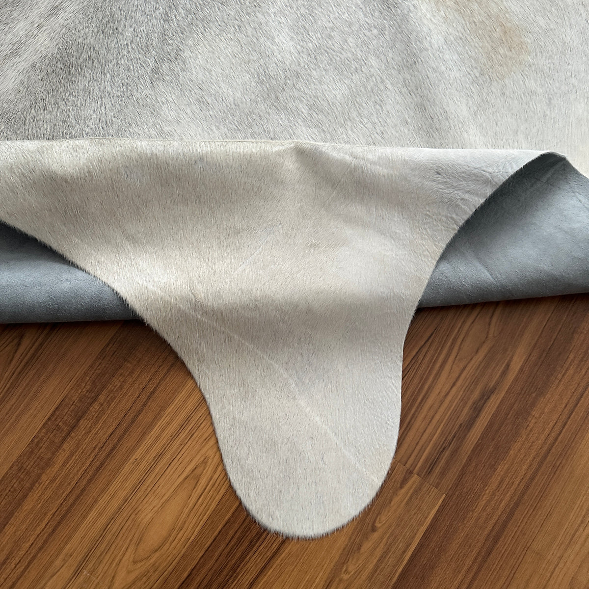 Close-up texture of Beige cowhide rug — Large irregular cream and light gray patches with natural organic mottling