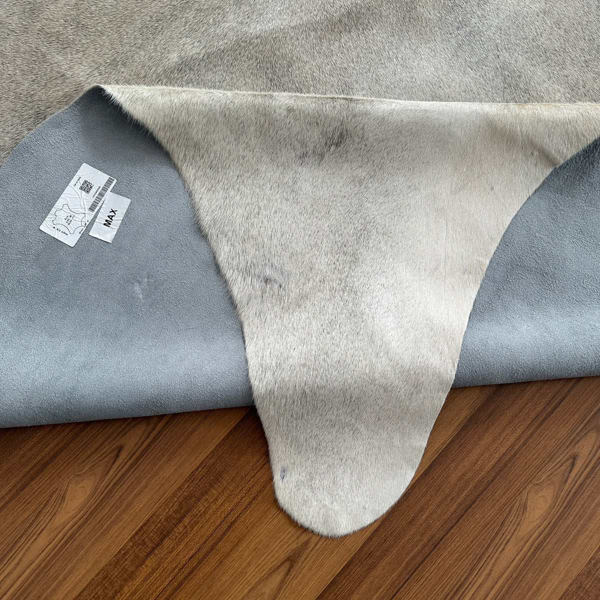 Close-up texture of Beige cowhide rug — Light cream base with scattered faint tan patches and natural hide markings
