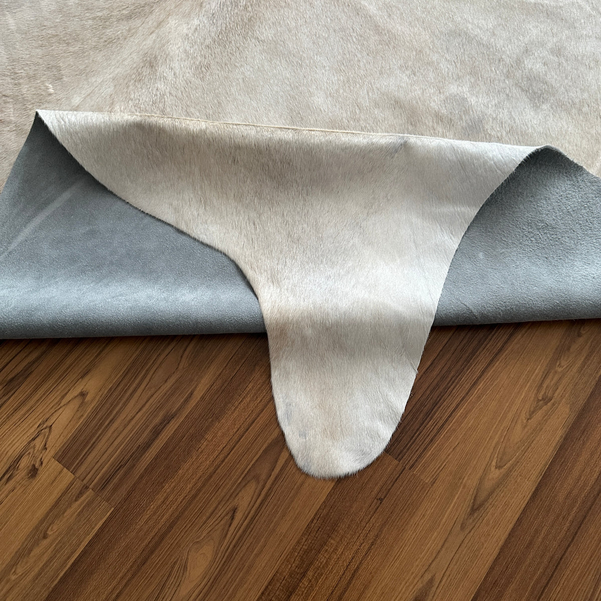 Close-up texture of Beige cowhide rug — Large irregular cream and light grey patches with natural tonal variation