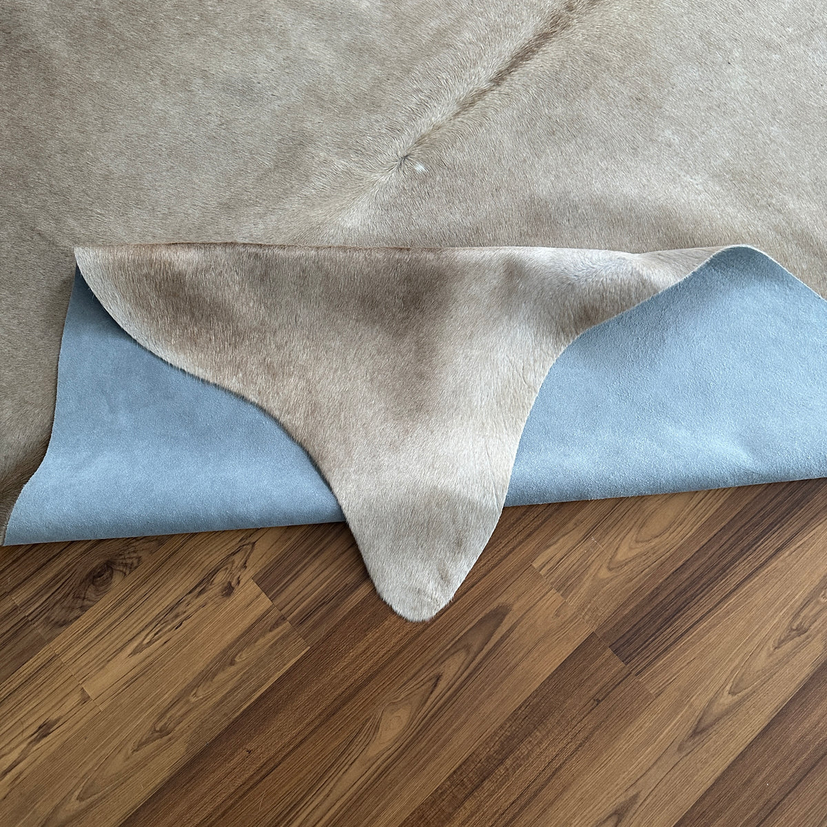 Close-up texture of Beige cowhide rug — Soft cream base with light tan and gray natural markings
