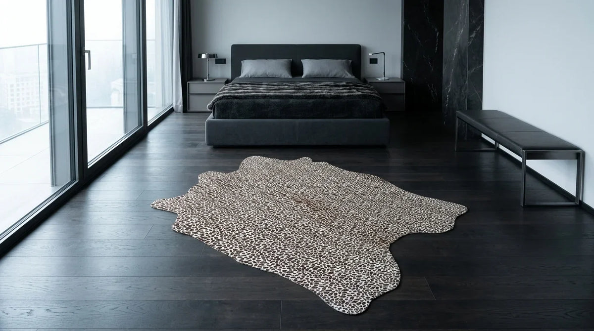 Black and White cowhide rug beside bed in milano penthouse bedroom